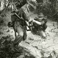 View: MR01596 Corporal Fitzhugh of 6 Platoon giving a helping hand to Bren Gunner Goodwin in the Pasir Panjang Ulu.