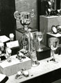 View: MR02128 Collection of trophy cups and silver bugle on display in local jewellers.
