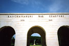 View: MR02322 The entrance to Kanchanaburi War Cemetery (a World War II cemetery) showing the Cross of Sacrifice through the centre arch.