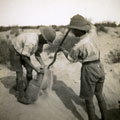 View: MR02619 Two men filling sandbags in desert