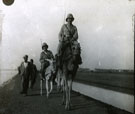View: MR02809 Two men, one on a camel and one on a donkey, with civilians