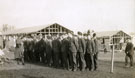 View: MR02889 Men, some in uniform and some in civilian dress, outside half built in Heaton Park