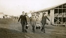 View: MR02894 Men from the Pals Battalions carrying carrying hot meals in metal dixies near semi-constructed hutments